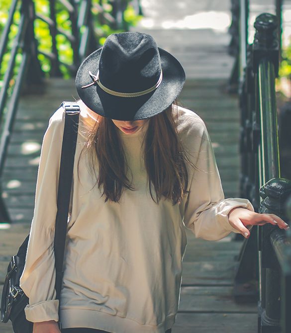 woman with a cool hat walking along the street